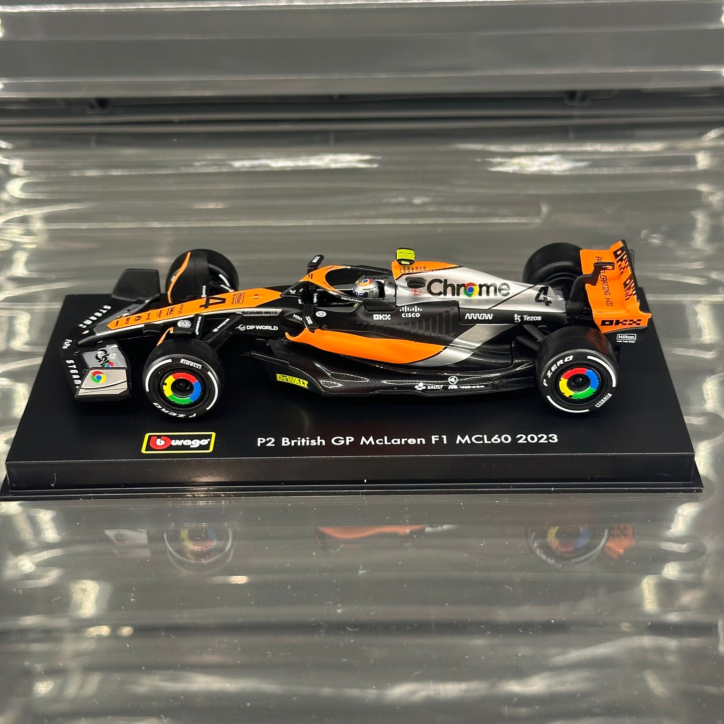 Bburago McLaren F1 MCL60 British GP Special Livery (2023) with Driver's Helmet & Showcase 1:43