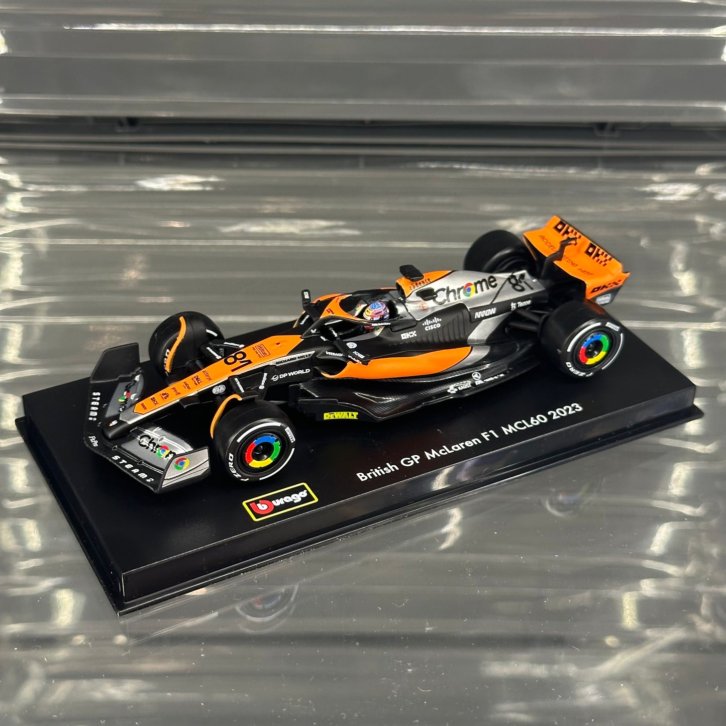 Bburago McLaren F1 MCL60 British GP Special Livery (2023) with Driver's Helmet & Showcase 1:43